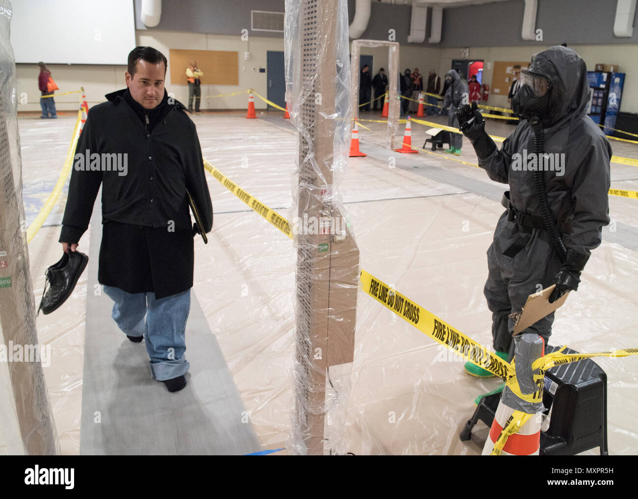 Un bénévole promenades à travers un détecteur de radiation alors qu'un soldat américain avec la 59e Compagnie CBRN de Fort Drum, New York, surveille les résultats lors d'un événement de formation conjointe sur Fort Hamilton, NY, le 1 décembre 2016. Cet événement a été la conclusion d'un exercice d'entraînement d'une semaine organisé par la ville de New York et du Nord de l'armée américaine, et supervisé par le U.S. Northern Command. Les événements a fourni à nos soldats et les premiers intervenants locaux l'expérience du travail en commun au cours d'un complexe chimique, biologique, radiologique ou nucléaire d'urgence. (U.S. Photo de l'Armée de l'air Tech. Le Sgt. Joe Lois) Banque D'Images