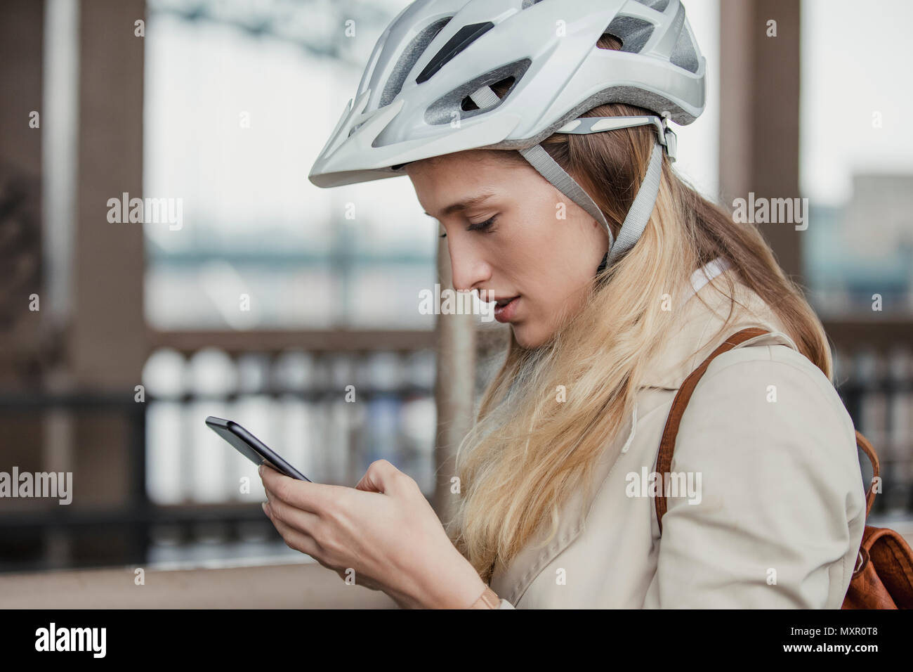 Vue latérale d'une femme d'utiliser son téléphone portable sur son cycle de travail. matin Banque D'Images