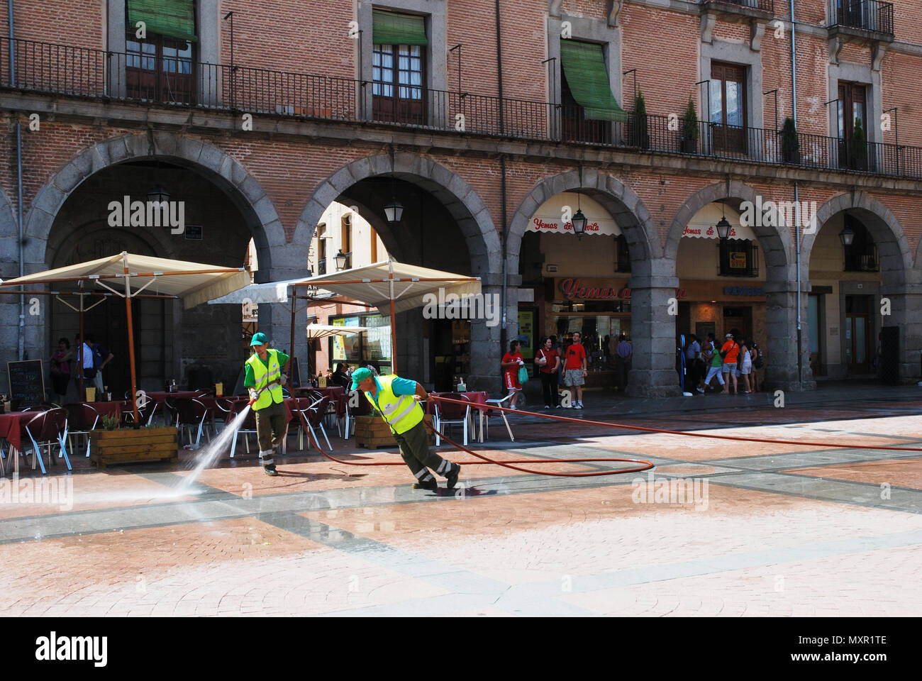 Les nettoyeurs de rue travaillant au Mercado Chico Square. Avila, Espagne. Banque D'Images