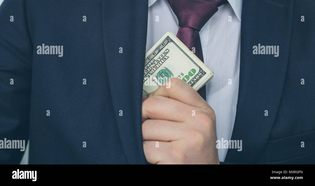Un homme d'affaires affiche une somme d'argent, le met dans sa poche de costume Banque D'Images