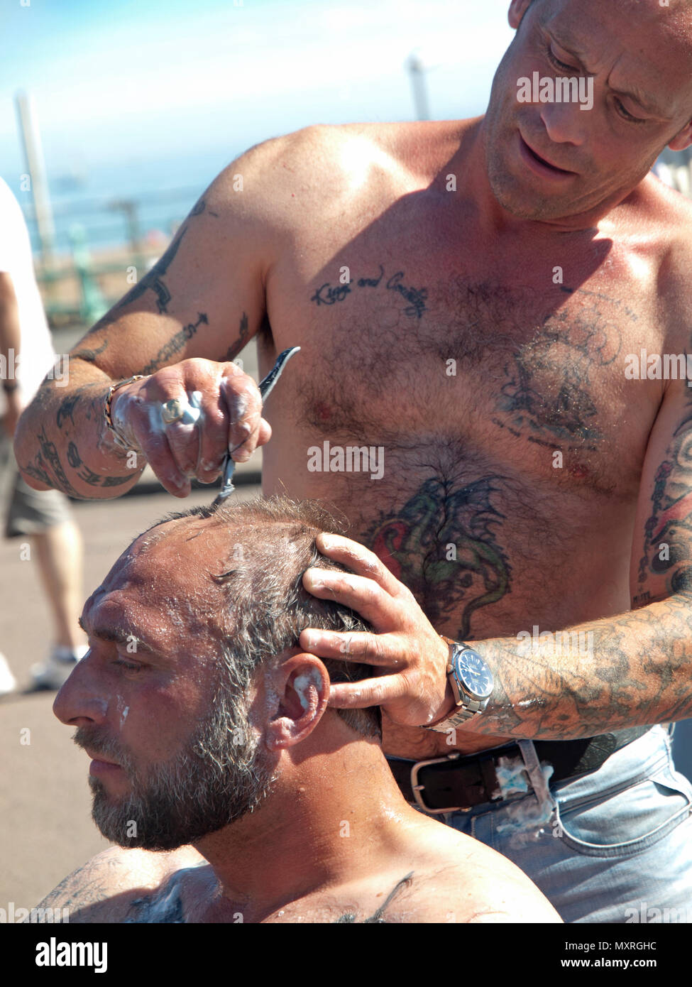 Lors d'une réunion de skinhead à Brighton un homme a sa tête rasée Banque D'Images