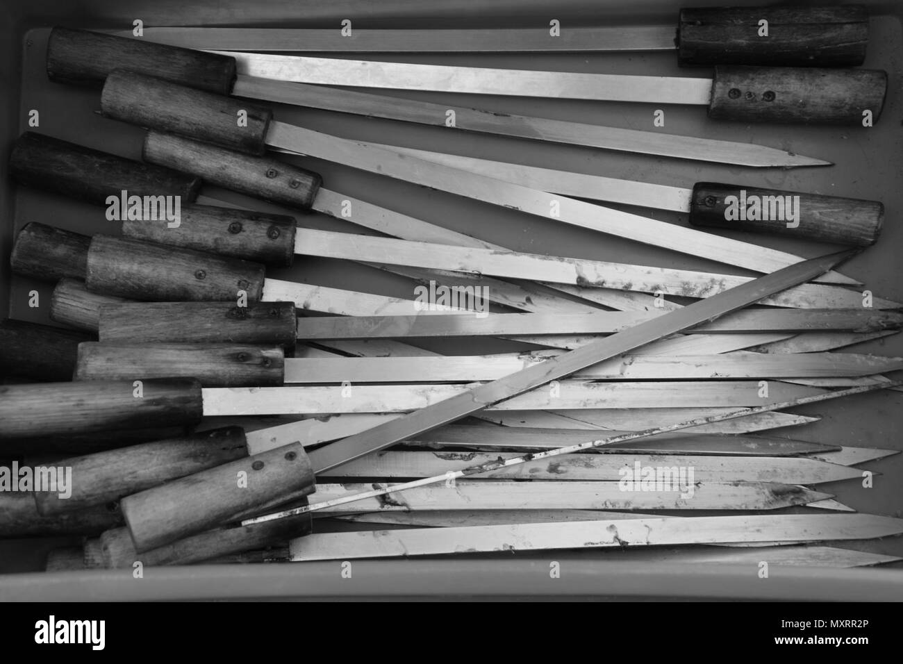 Brochettes de métal sale après un barbecue dans une boîte en noir et blanc optique Banque D'Images