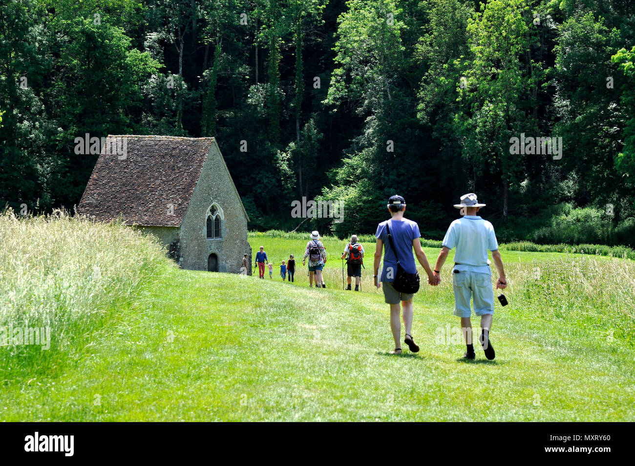 Saint-Ceneri-le-Gerei (Normandie, nord-ouest de la France). Groupe de randonneurs faisant face à la chapelle de ce village des Alpes Mancelles région appelée l'un o Banque D'Images