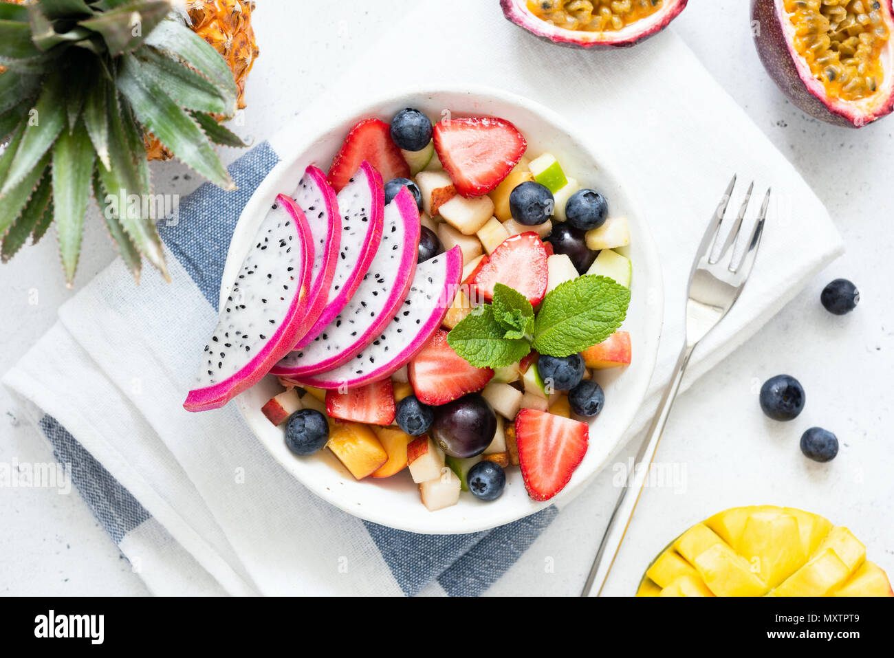 Salade de fruits tropicaux avec fruit du dragon et la mangue dans un bol. Salade de fruits exotiques aux couleurs vives sur fond blanc, dessus de table view Banque D'Images