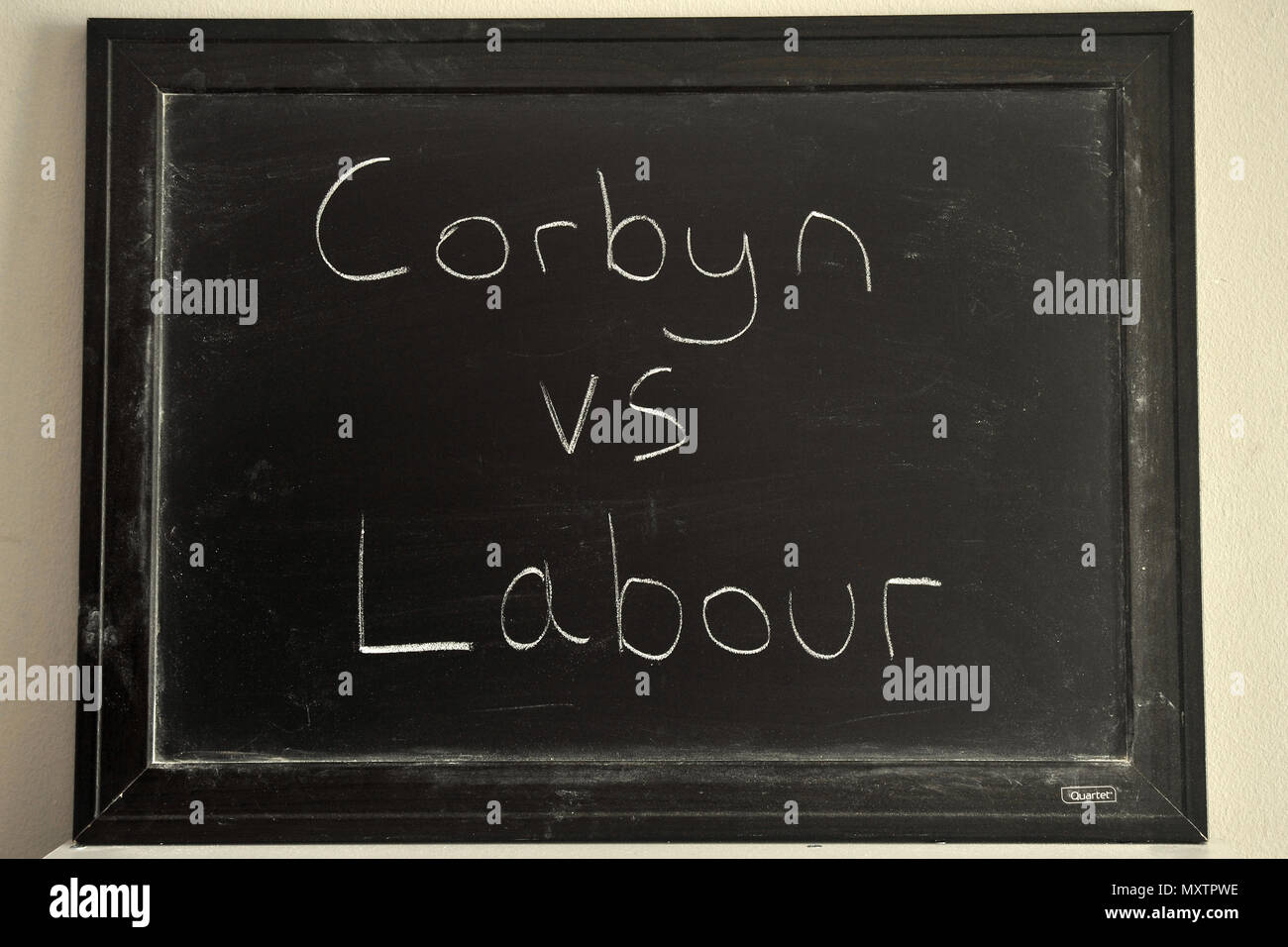 Corbyn Travail vs écrit en craie blanche sur un tableau noir. Banque D'Images
