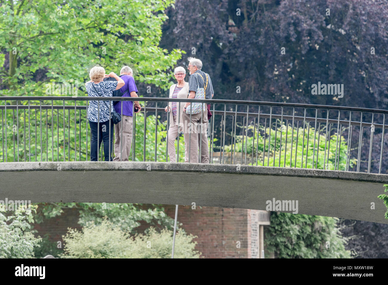 Une paire de couples retraités sur Garret Hostel lane pont sur la rivière Cam à Trinity Hall College, Université de Cambridge, en Angleterre, sous le soleil d'été Banque D'Images