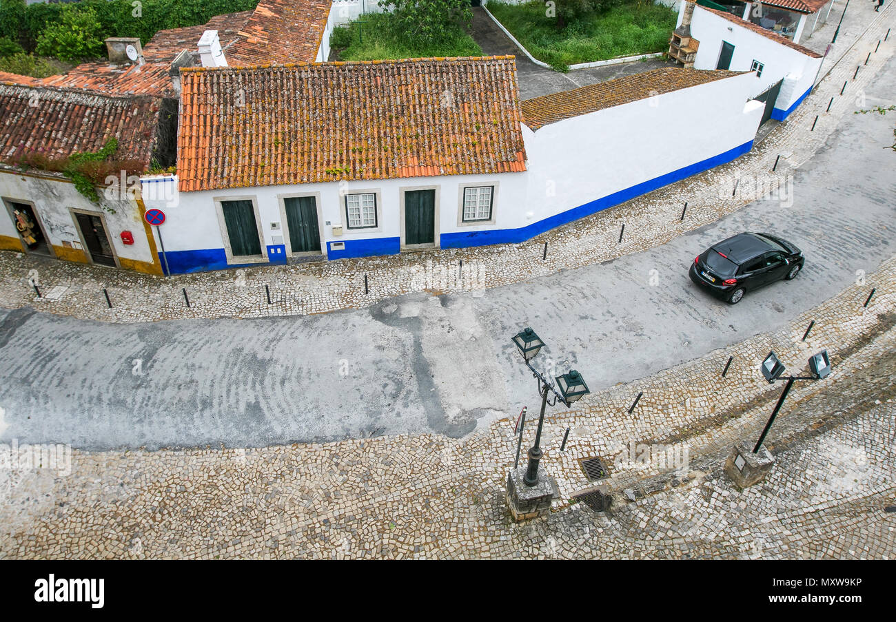 Voiture roule le long d'une rue à Obidos, Portugal juste à l'extérieur du mur. Banque D'Images