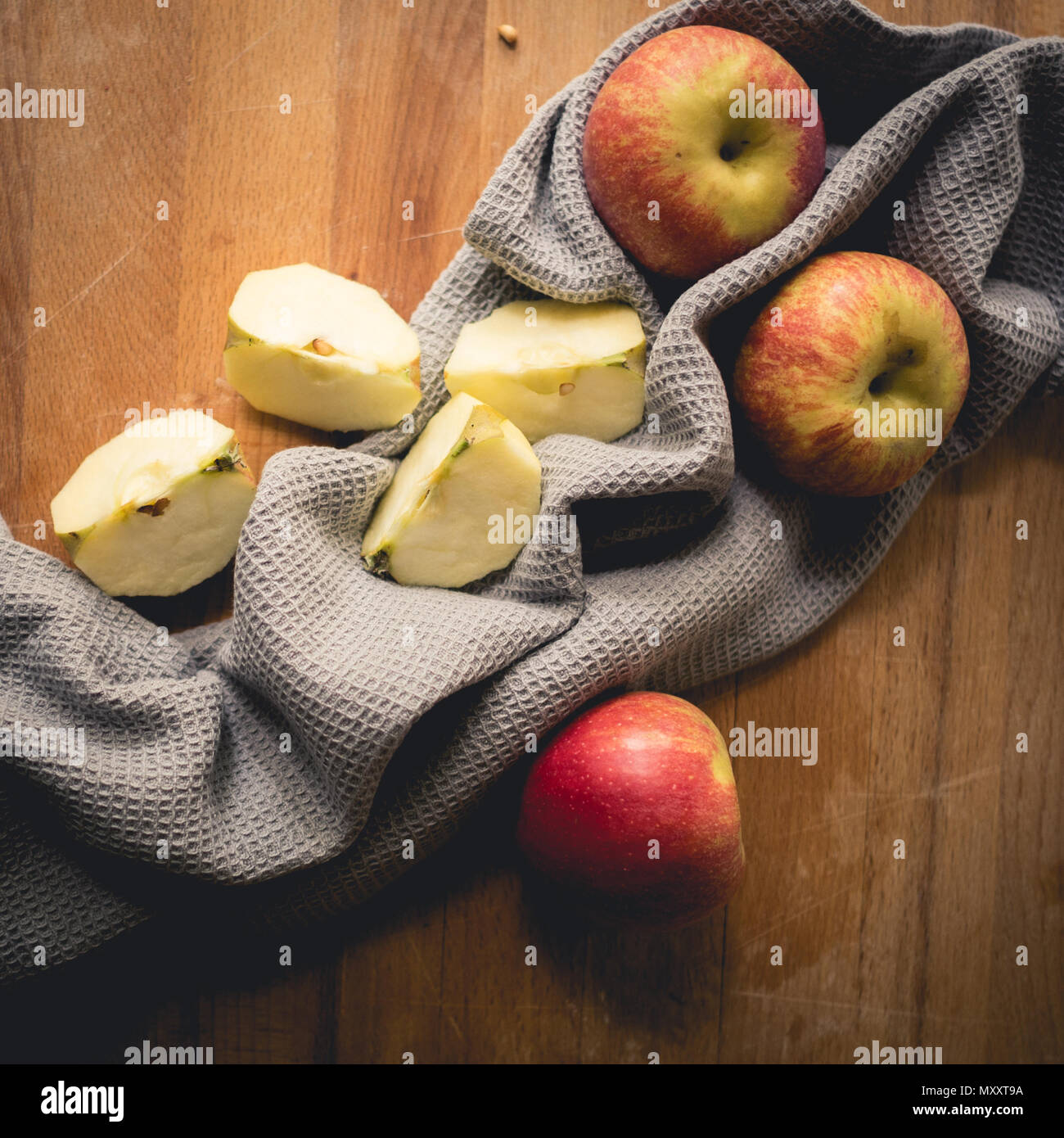 Vue de dessus de pommes sur une planche en bois avec un chiffon de cuisine gris. Format carré. Banque D'Images