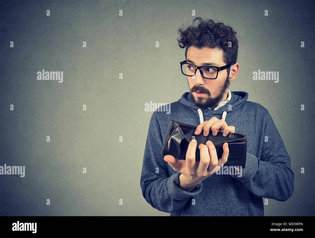 En montrant l'homme Hipster verres vide wallet ayant des problèmes avec le vol d'argent et de faillite. Banque D'Images