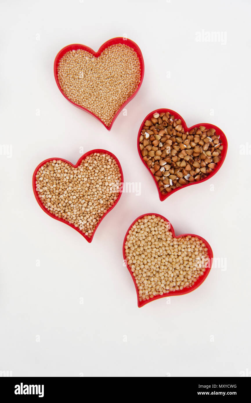 Cœurs remplis de l'amarante, le millet, le sarrasin et le quinoa isolated on white Banque D'Images