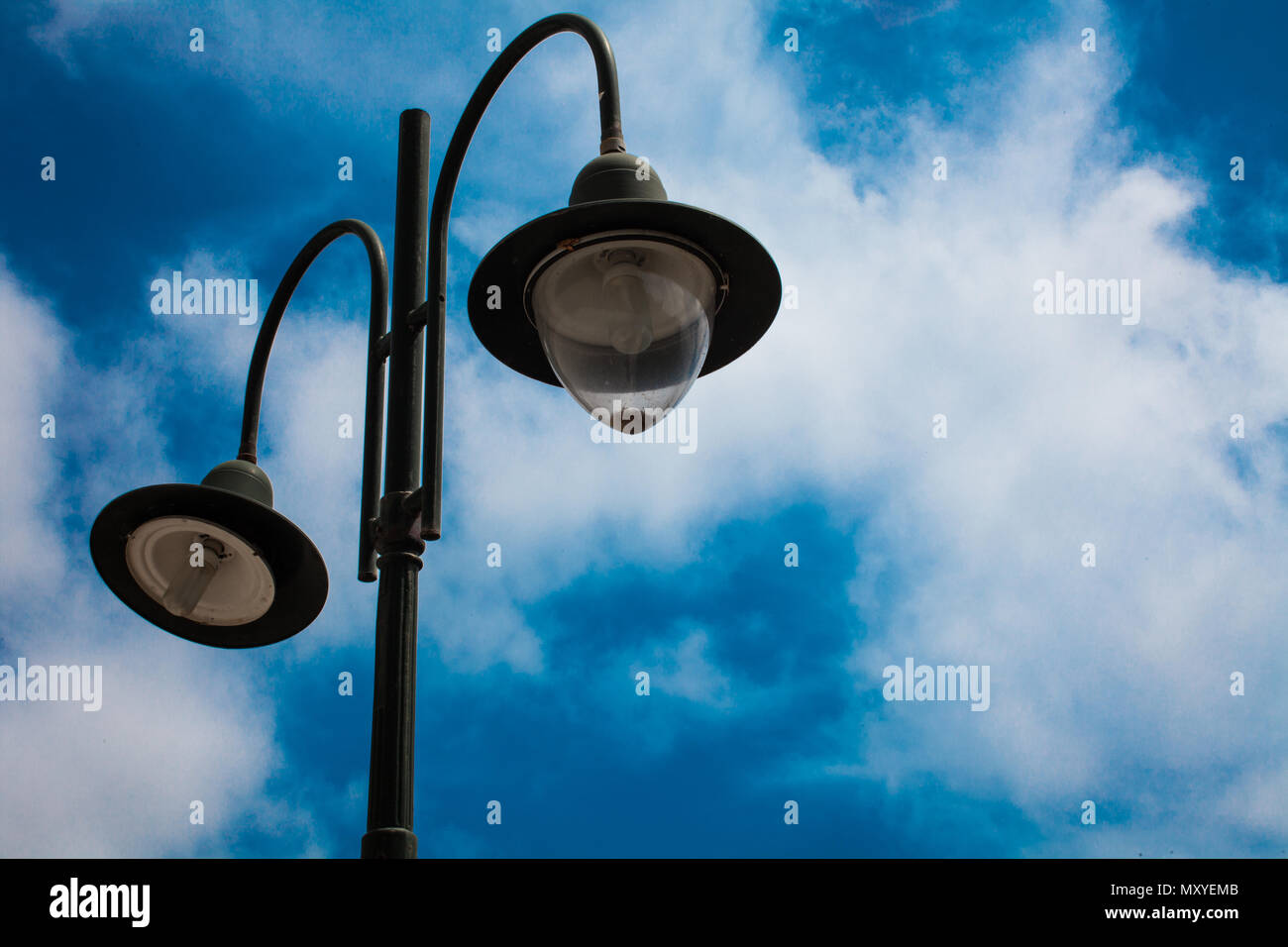 Lampadaire avec deux ampoules et bleu ciel nuageux fond. Lumières de rue en  plein air. Lampe en fonte. De grandes lanternes. Mât d'éclairage.  S'ALLUMER. Installation électrique Photo Stock - Alamy