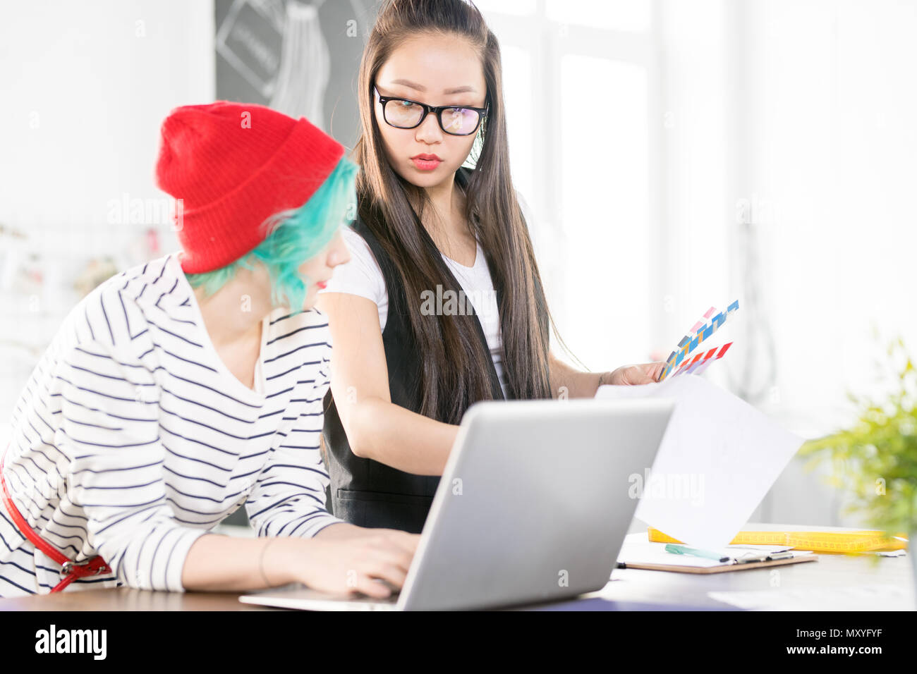 Portrait de deux jeunes femmes travaillant la création contemporaine en design de mode à l'aide d'ordinateur portable et la collaboration sur le projet de tableau de l'article personnalise mod Banque D'Images