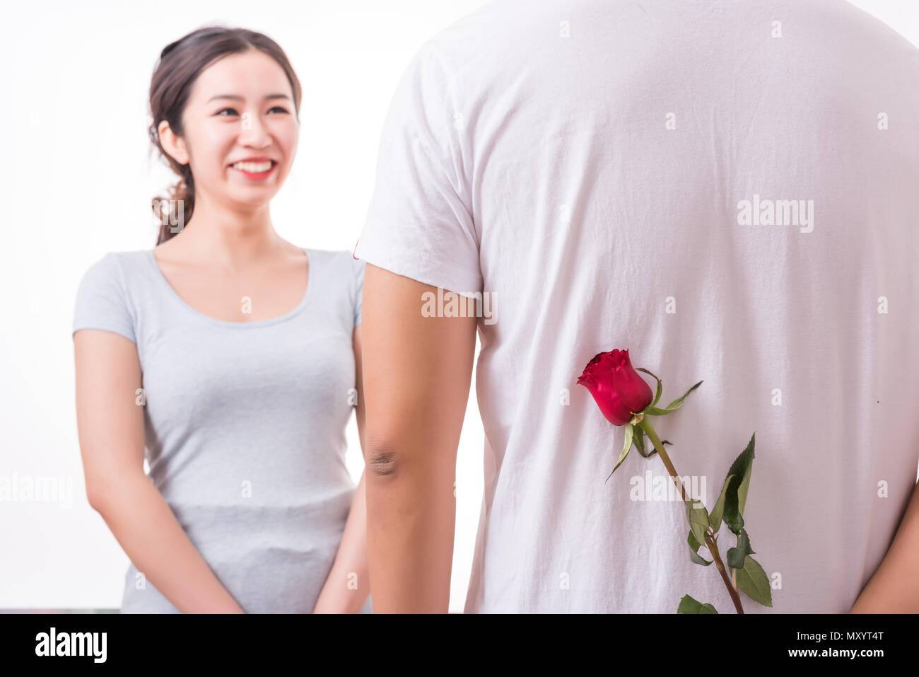 Jeune couple dans l'amour, Man holding surprise rose pour la belle jeune femme. Valentines Day. L'amour. Banque D'Images