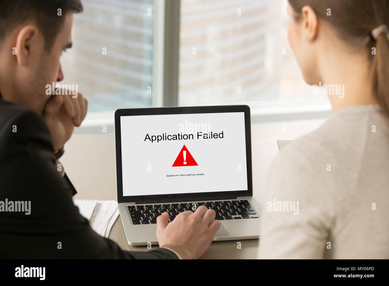 Deux personnes regardant un écran d'ordinateur portable avec l'application n'a pas de message d'erreur. Businessman with female client panne du système au cours de l'expérience pr Banque D'Images