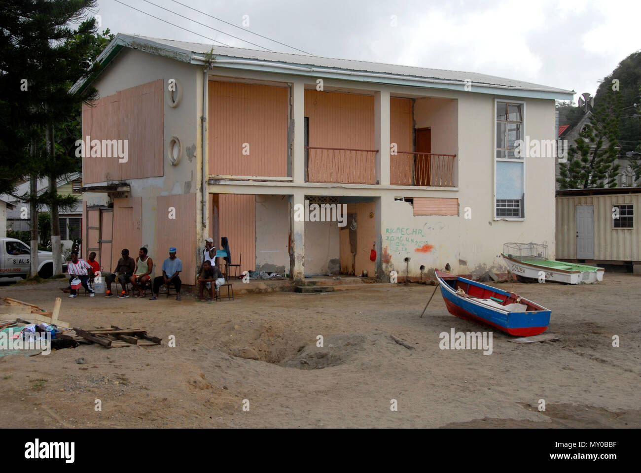 Groupe d'hommes au chômage assis à côté du bâtiment délabré, Sainte-Lucie, Caraïbes Banque D'Images