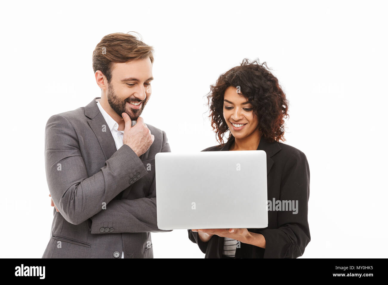Portrait of a smiling woman looking at laptop computer isolé sur fond blanc Banque D'Images