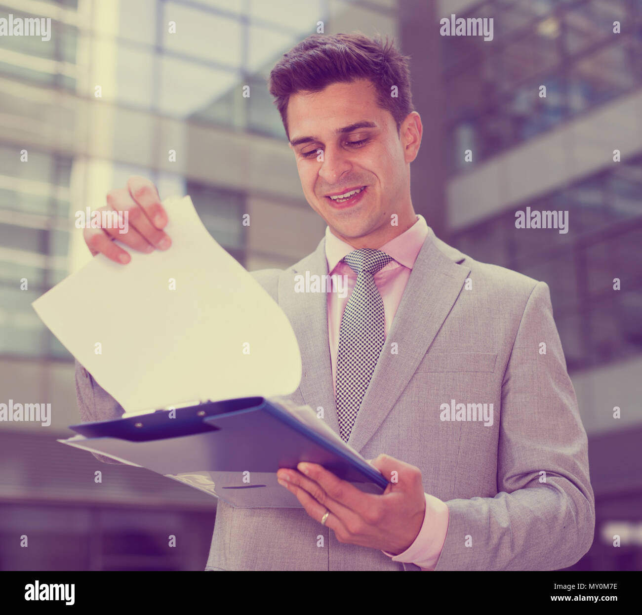 Businessman holding folder avec des documents et de contentement lecture Banque D'Images