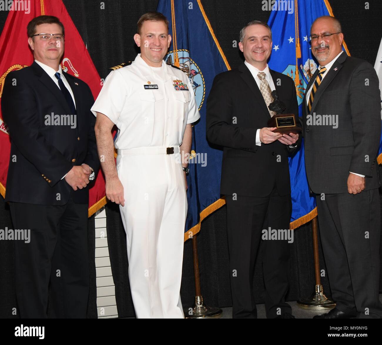 DAHLGREN, en Virginie (26 avril 2018) - Frank Peterkin détient le prix John Adolphus Dahlgren instants après réception de celui-ci de la Naval Surface Warfare Center Dahlgren Division (NSWCDD) le leadership à l'honneur annuel du commandement cérémonie de remise des prix. Peterkin a été reconnu pour fournir un leadership visionnaire dans l'avancement des technologies de l'énergie dirigée et capacités pour la Marine. Il a géré un portefeuille croissant de programmes à énergie dirigée, menant plusieurs efforts de réaction rapide pour inclure la première réussite de l'emploi tactique d'une arme à énergie dirigée, selon la citation. Debout, de gauche à ri Banque D'Images