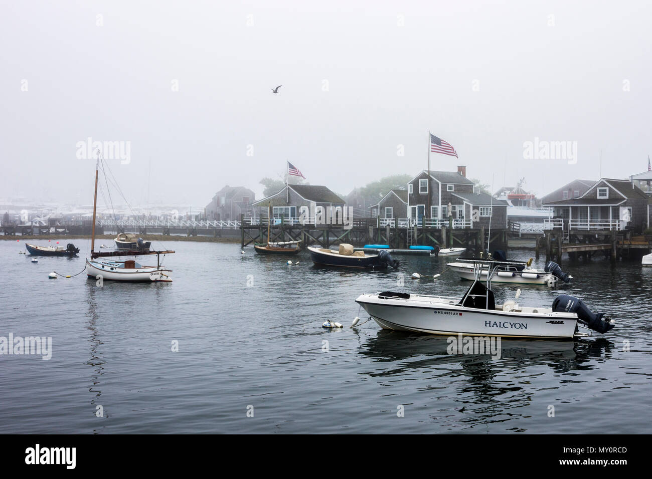 L'île de Nantucket, Massachusetts. Vue sur le port de Nantucket avec des bateaux et des maisons traditionnelles en bois sur une journée d'été brumeux Banque D'Images