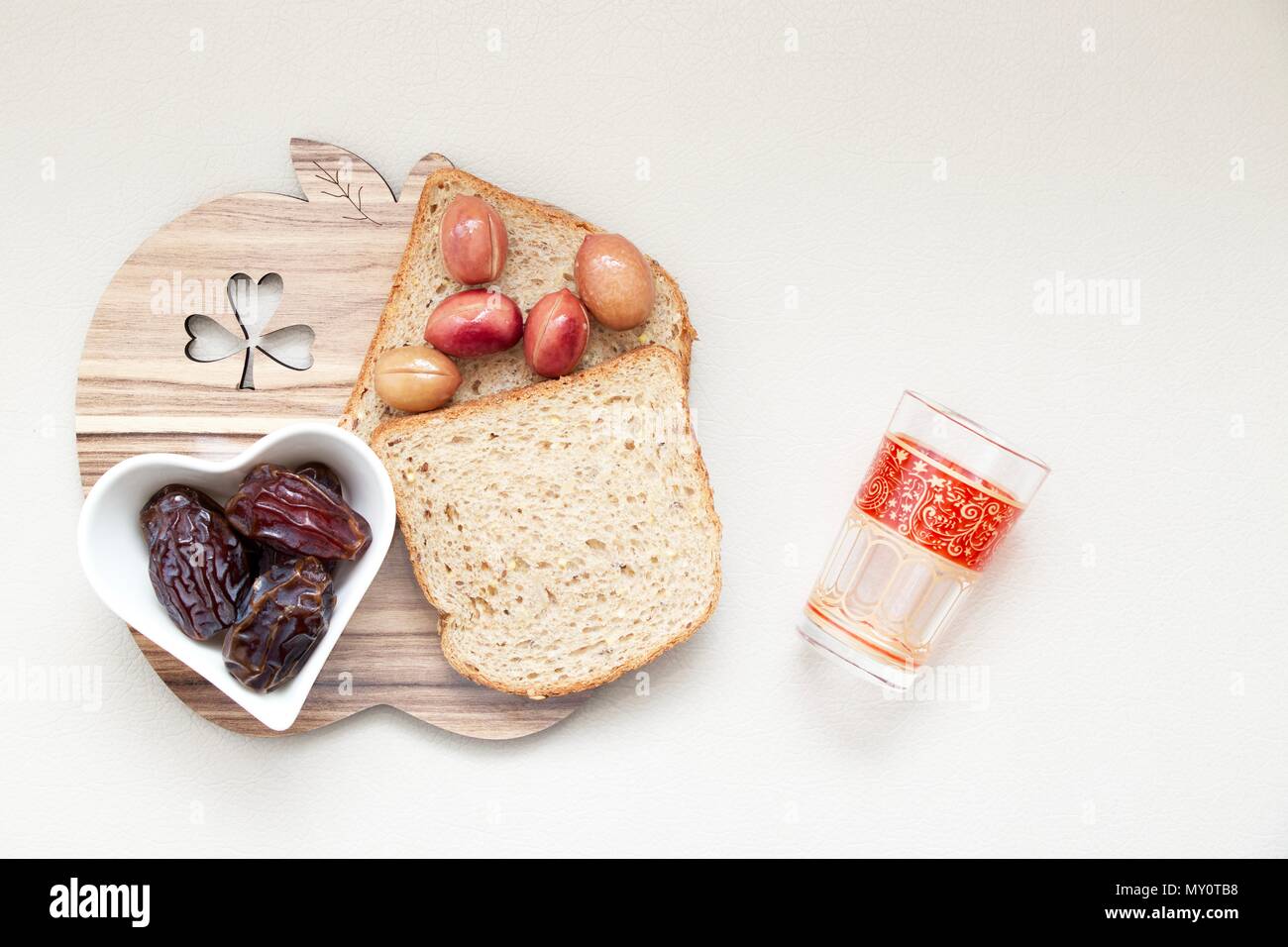 Ramadan Kareem célébration avec date islamique, olive, verre de l'eau, pain aliments sur fonds blancs Banque D'Images