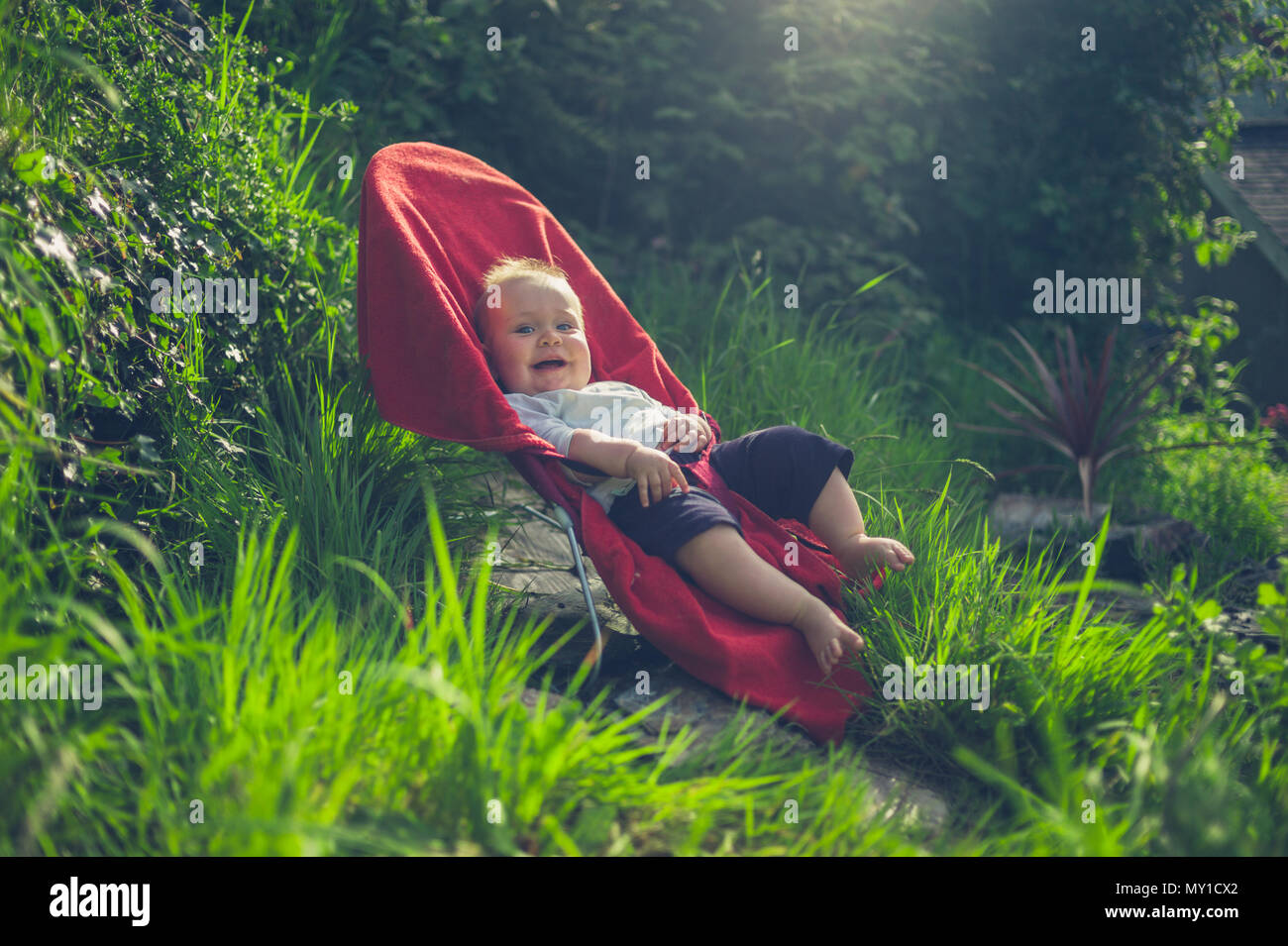 Un Petit Bebe Est Assis Dans Un Fauteuil Gonflable A L Exterieur Dans Le Jardin Photo Stock Alamy