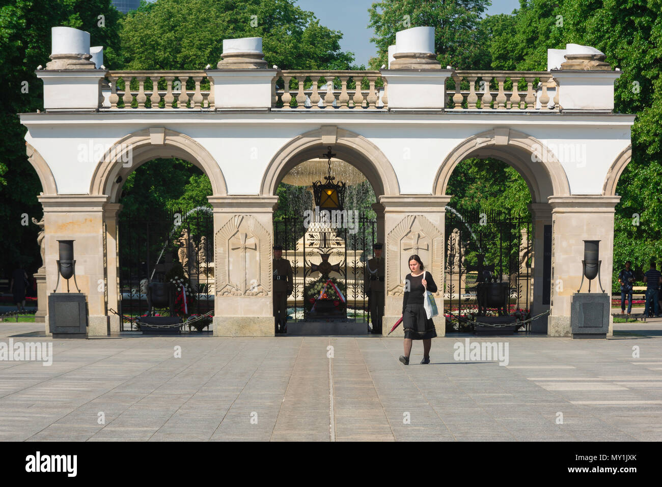 Mémorial de la guerre de Pologne, vue d'une jeune femme vêtue passant devant le tombeau du soldat inconnu sur la place Pilsudski (Plac Pilsudski), Varsovie, Pologne. Banque D'Images