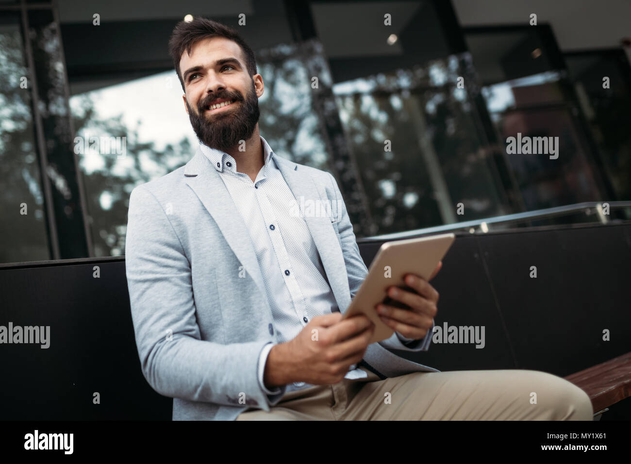 Shot of businessman sitting on bench with digital tablet Banque D'Images