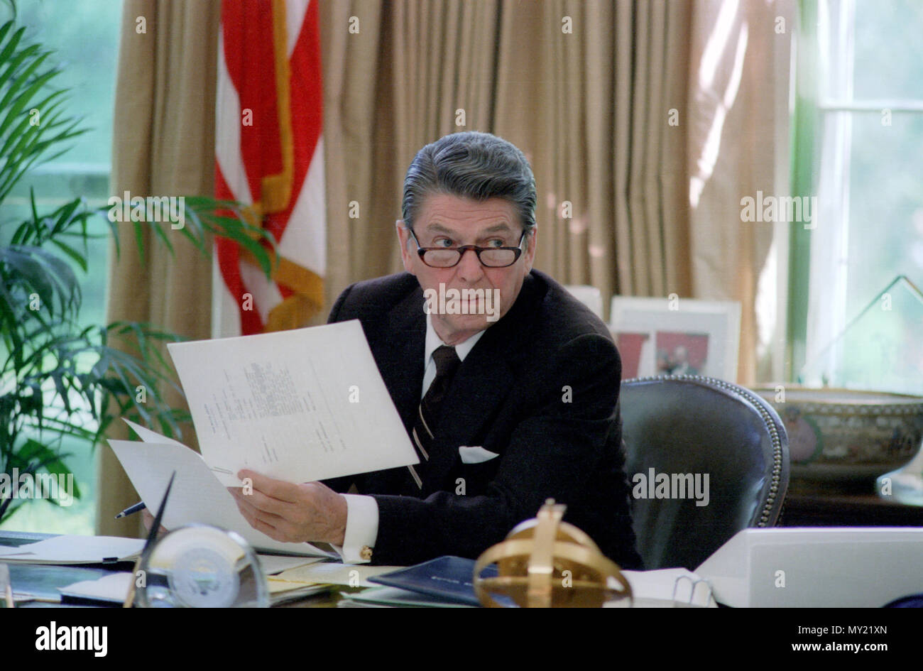 5/6/1982 Le président Reagan portant des lunettes tout en travaillant à son bureau dans le bureau ovale Banque D'Images