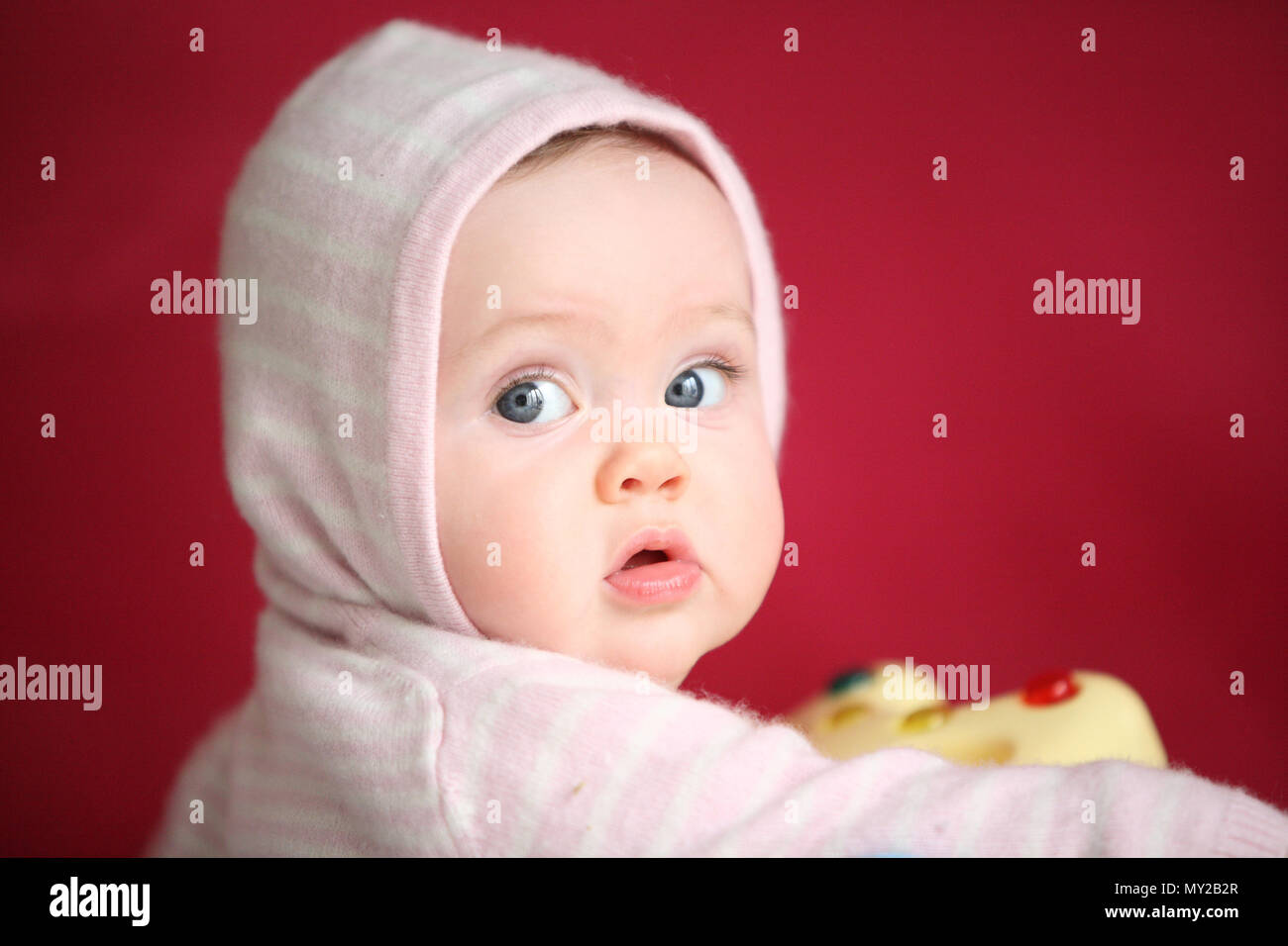 Un Mignon Curieux Trop Jeune Bebe Portant Rose Sur Fond Rose Cerise 0 A 6 6 A 12 L Age De Douze Mois Photo Stock Alamy