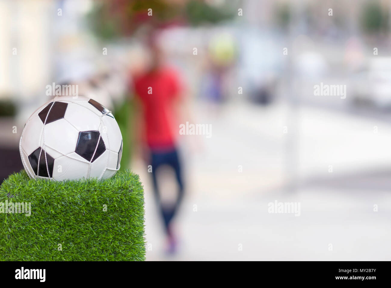 Stand de décoration sous la forme de la balle de football classique dans le filet sur l'herbe verte. Ornements des rues de la ville Banque D'Images