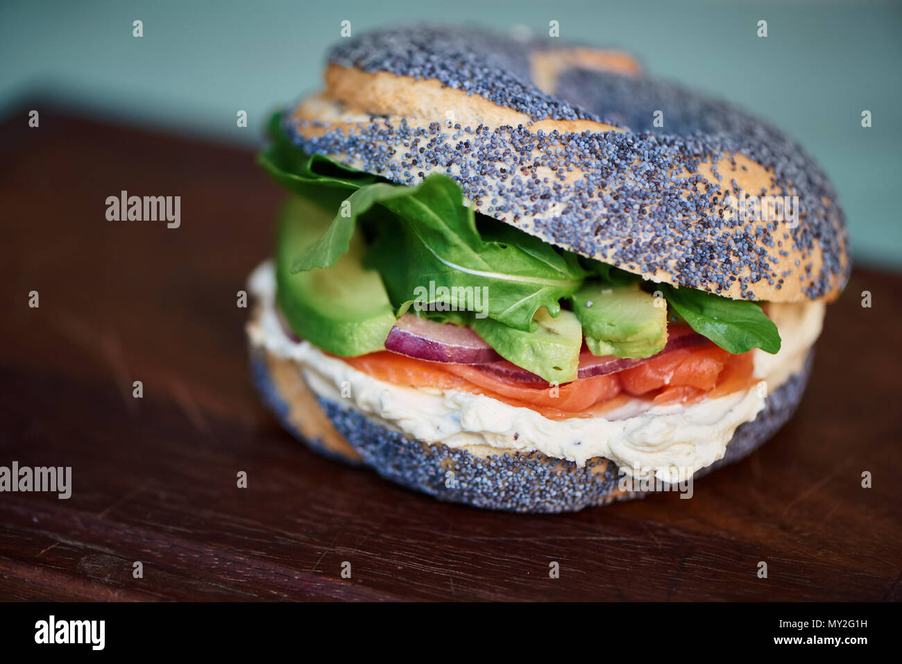 Libre d'un délicieux fromage à la crème et saumon bagel au pavot avec légumes assis sur un sol en bois servant de sélection Banque D'Images Libre d'un délicieux fromage à la crème et saumon bagel au pavot avec légumes assis sur un sol en bois servant de sélection Banque D'Images