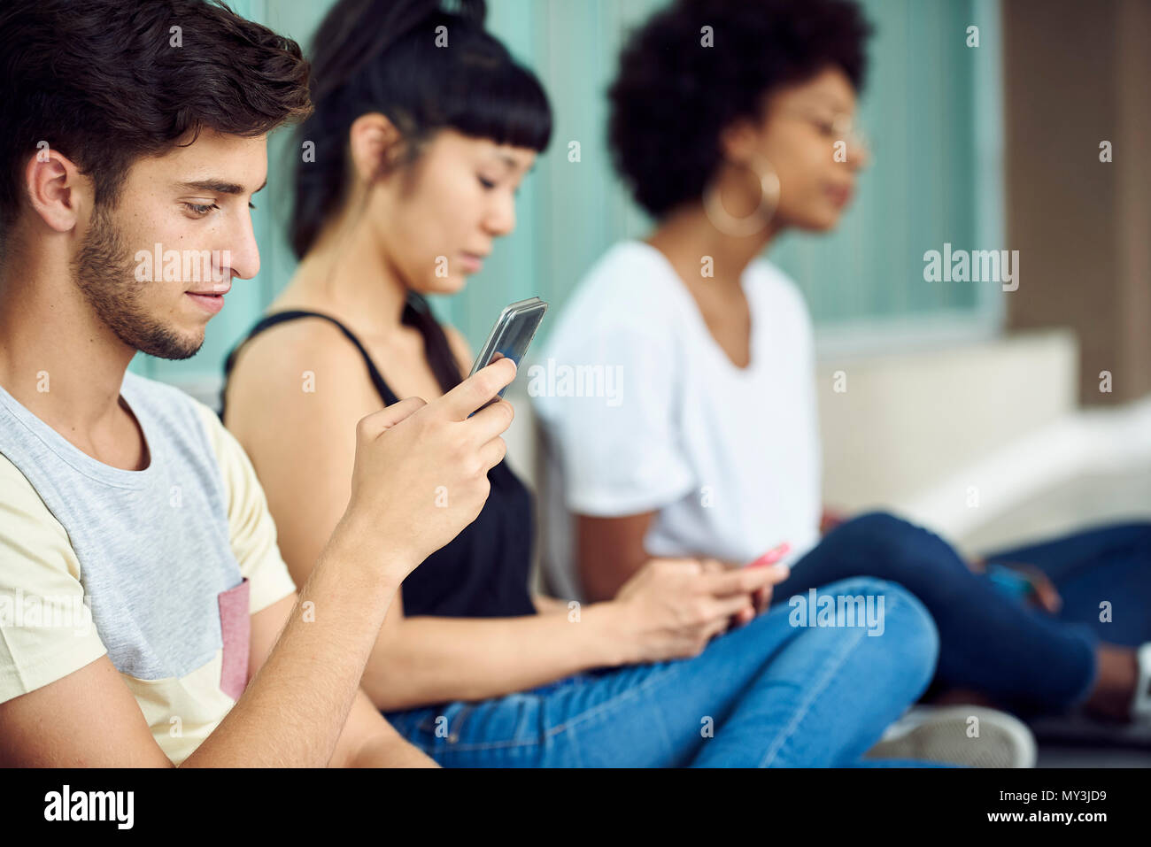 Les élèves à passer le temps avec les smartphones entre classes Banque D'Images