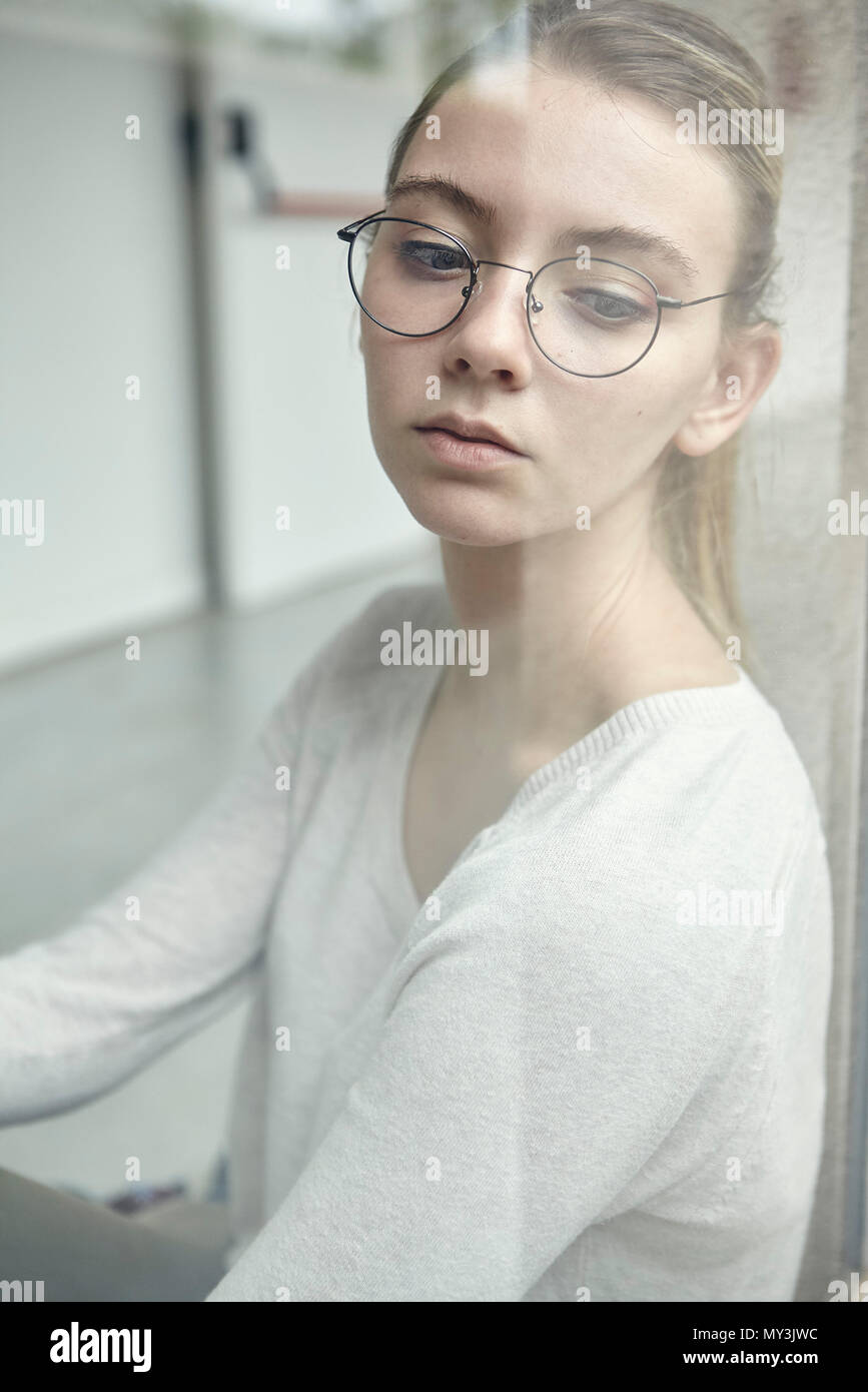 Jeune femme à la recherche d'une fenêtre, portrait Banque D'Images