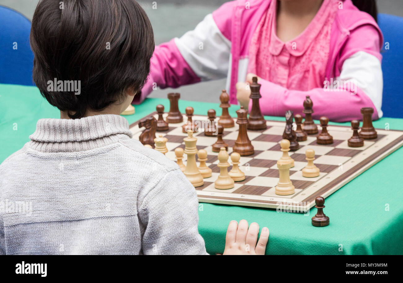 Les enfants (garçon et fille) jouant aux échecs en plein air en Espagne Banque D'Images