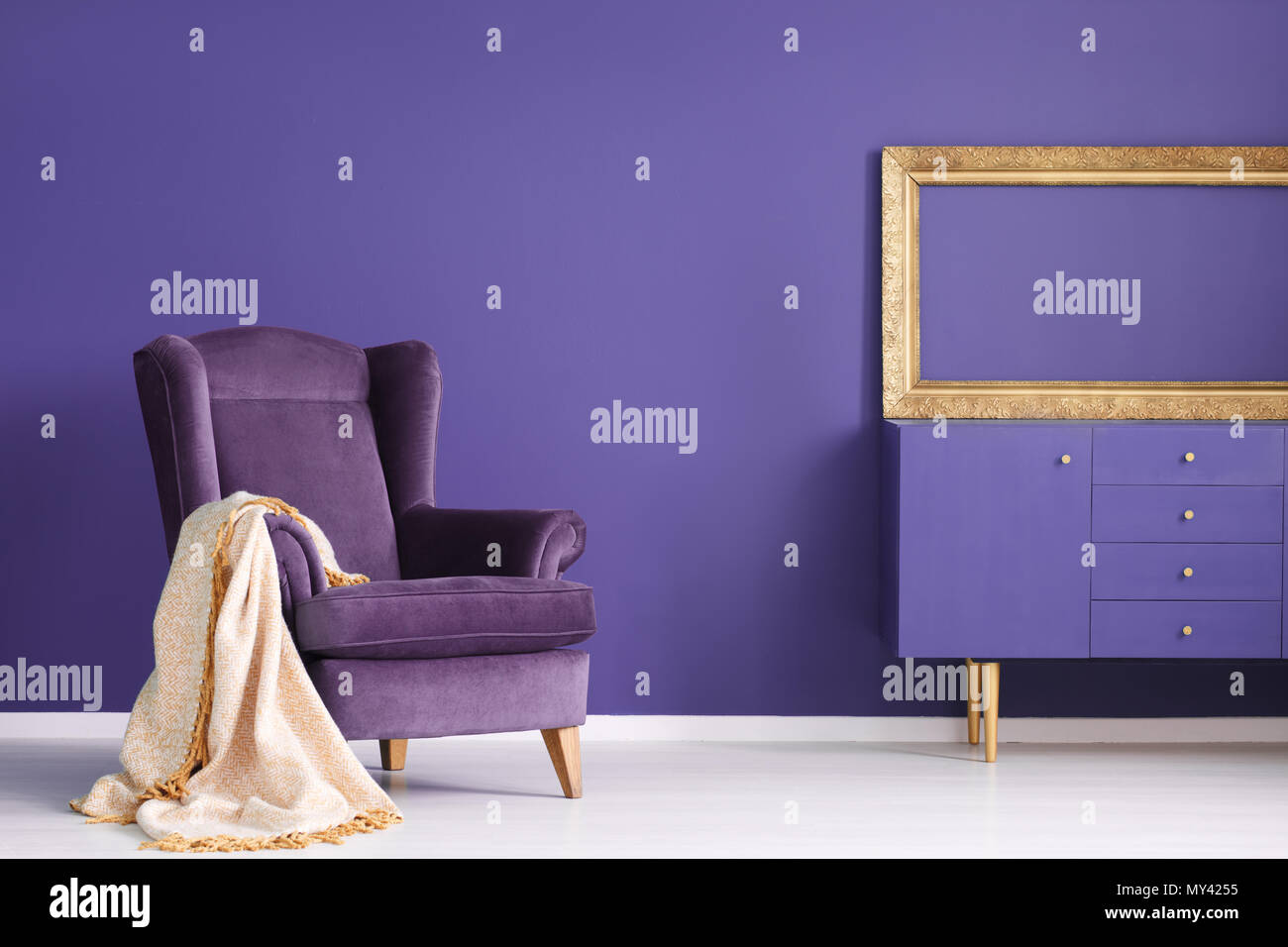 Couverture sur l'or en daim violet fauteuil dans le salon intérieur avec maquette de cadre vide Banque D'Images