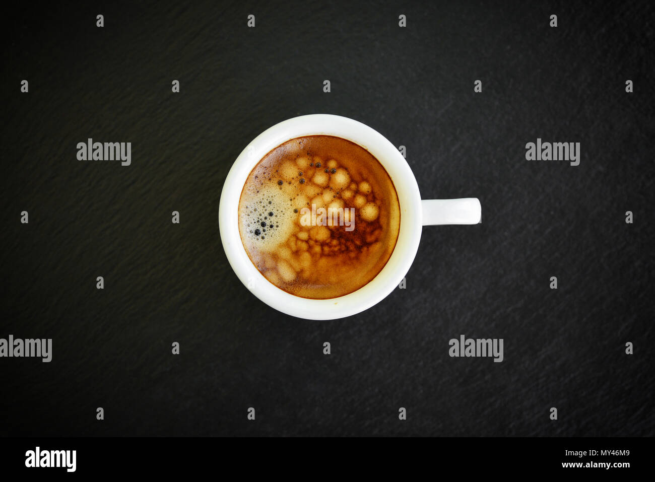 Café espresso dans small white cup sur fond d'ardoise noire, vue du dessus Banque D'Images