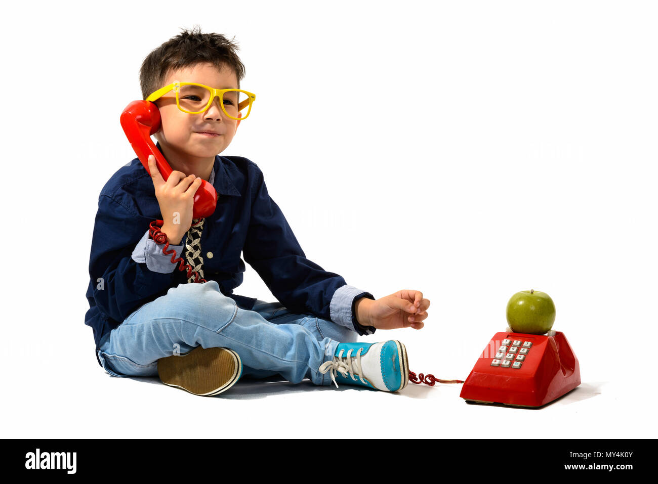 Portrait of cute boy talking on old telephone Banque D'Images