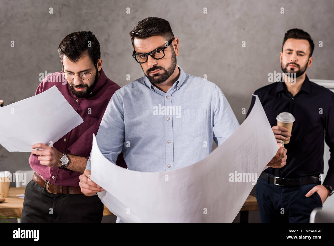 Handsome young architects with blueprints in office Banque D'Images