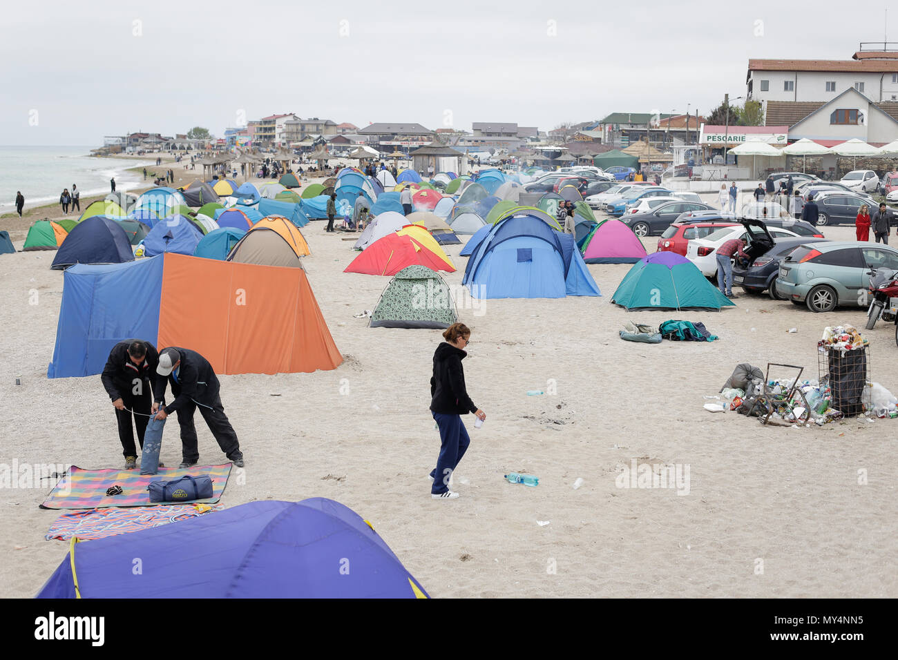 VAMA VECHE, ROUMANIE - 1 mai 2018 : les jeunes reste sur la plage, au milieu des débris (en particulier des bouteilles vides), après avoir fait la fête toute la nuit, au début de la mo Banque D'Images