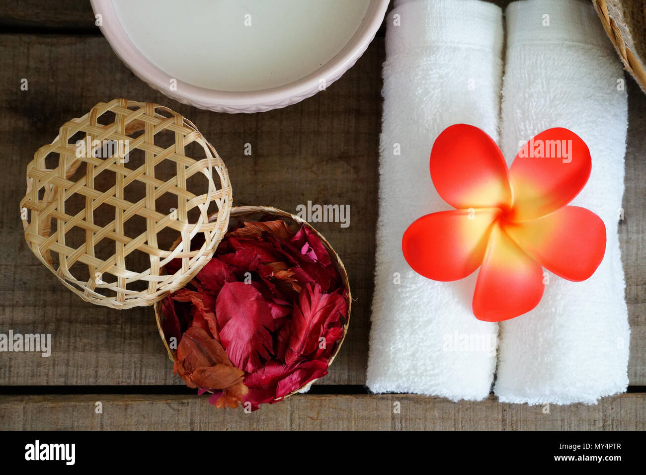 Décorer avec des serviettes blanches fleur orange près de dry aroma spa rose sur set. Banque D'Images