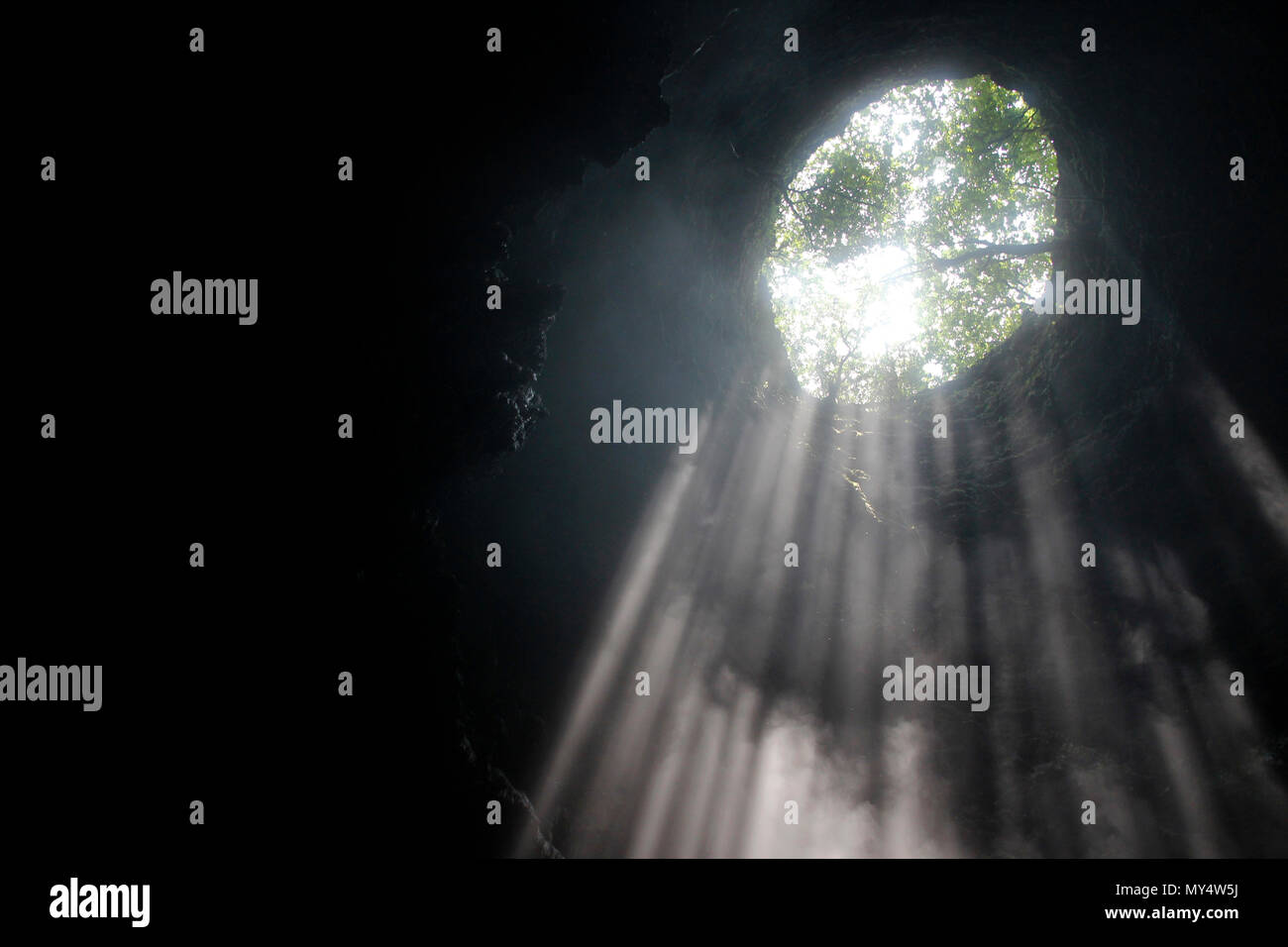 Lumière du soleil à travers la grotte grotte Jomblang trou à midi près de l'heure à Yogyakarta, Indonésie Banque D'Images