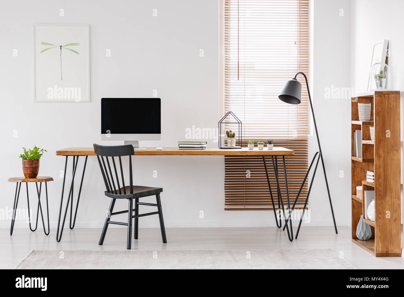 À côté de bureau en bois avec le moniteur de l'ordinateur de bureau à domicile avec l'intérieur de l'affiche. Photo réelle Banque D'Images