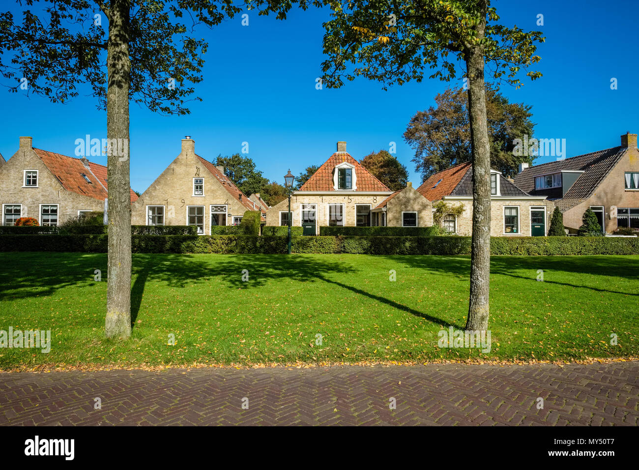 Ancien et superbe maisons sont éparpillées le long de la rue principale du village de Schiermonnikoog Wadden néerlandais sur l'île du même nom. Banque D'Images