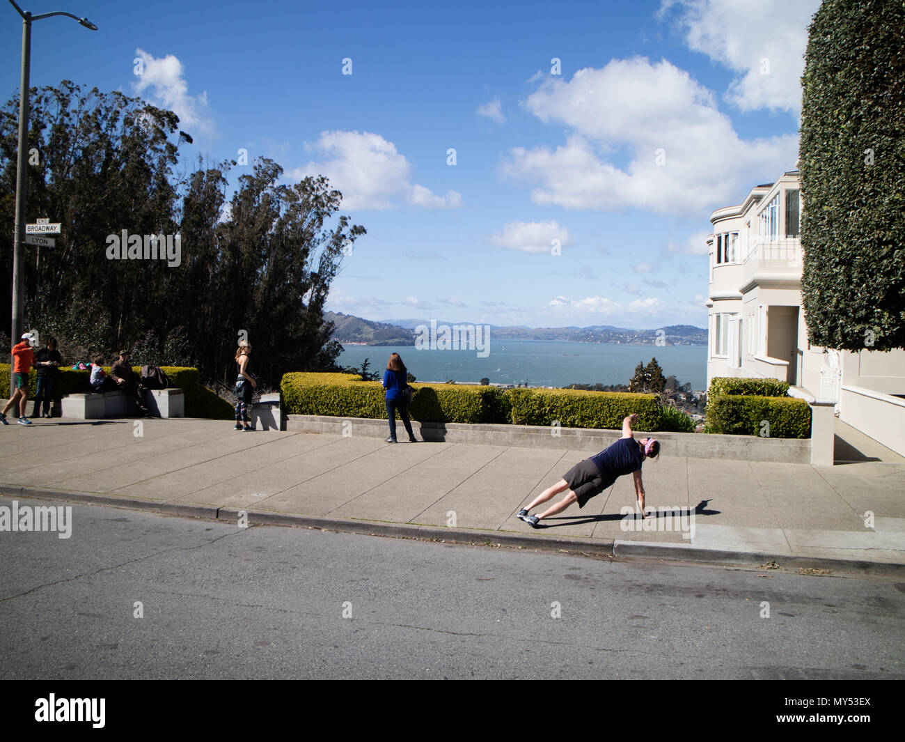 Une personne faisant un autre appuyez sur Haut sur le trottoir sur un dimanche après-midi ensoleillé à San Francisco avec une vue sur la baie à l'arrière-plan Banque D'Images