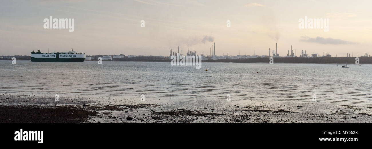 Le coucher du soleil les silhouettes des tours industrielles de Fawley raffinerie de pétrole sur les côtes de Southampton Water, vu de Netley. Banque D'Images