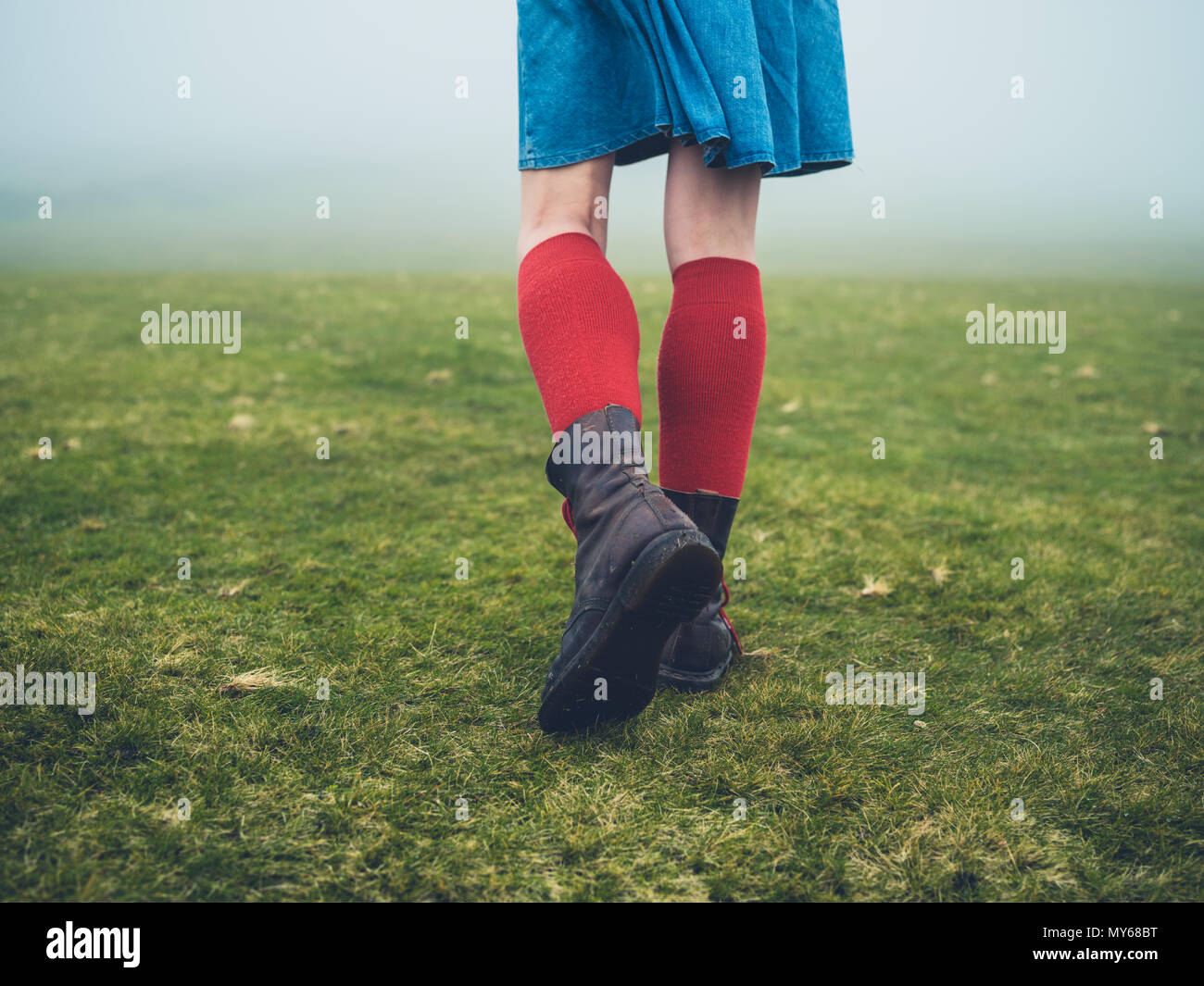Une jeune femme portant des chaussures et chaussettes marche sur la lande dans le brouillard Banque D'Images