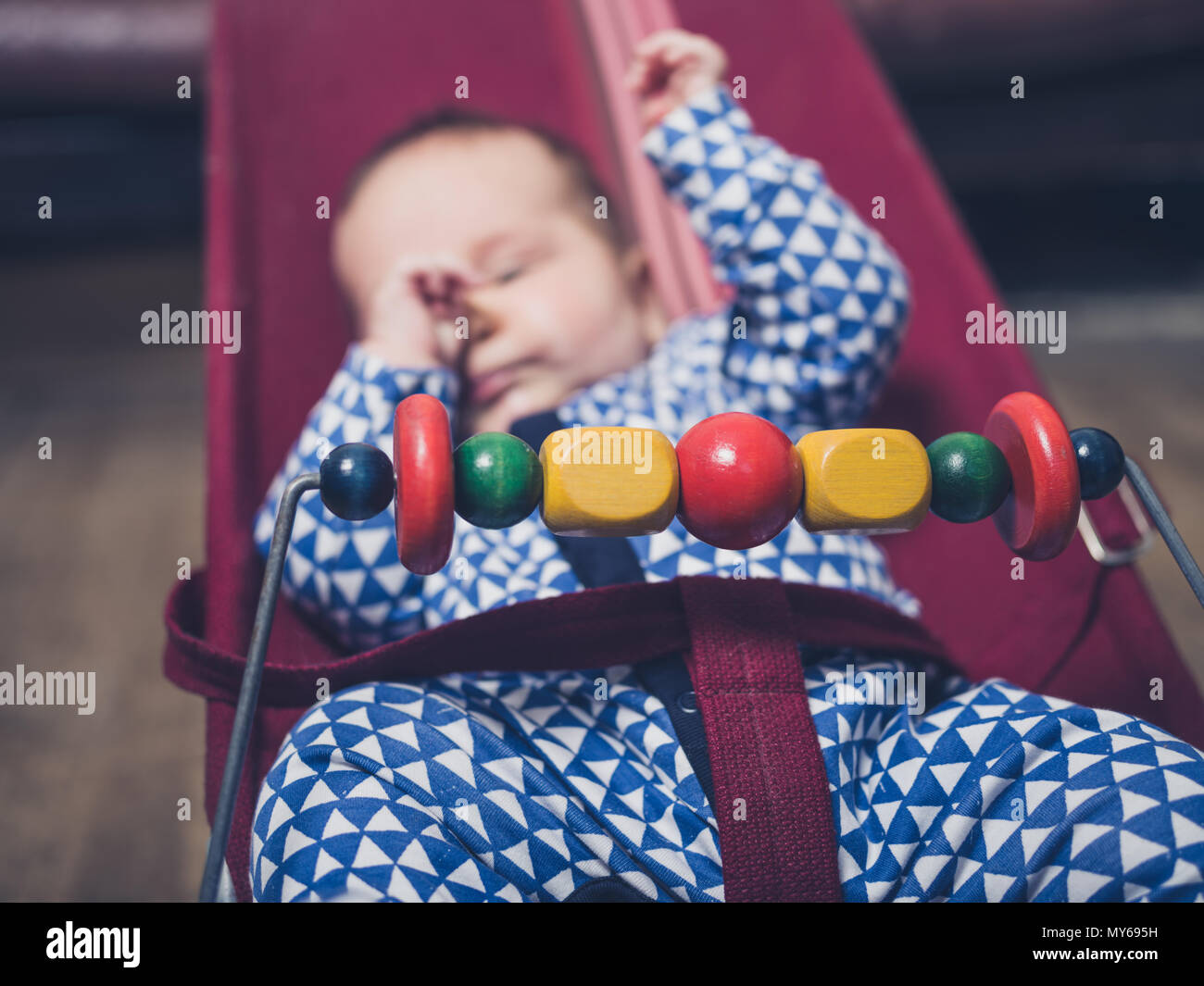Fatigué d'un bébé est assis dans un fauteuil gonflable Banque D'Images