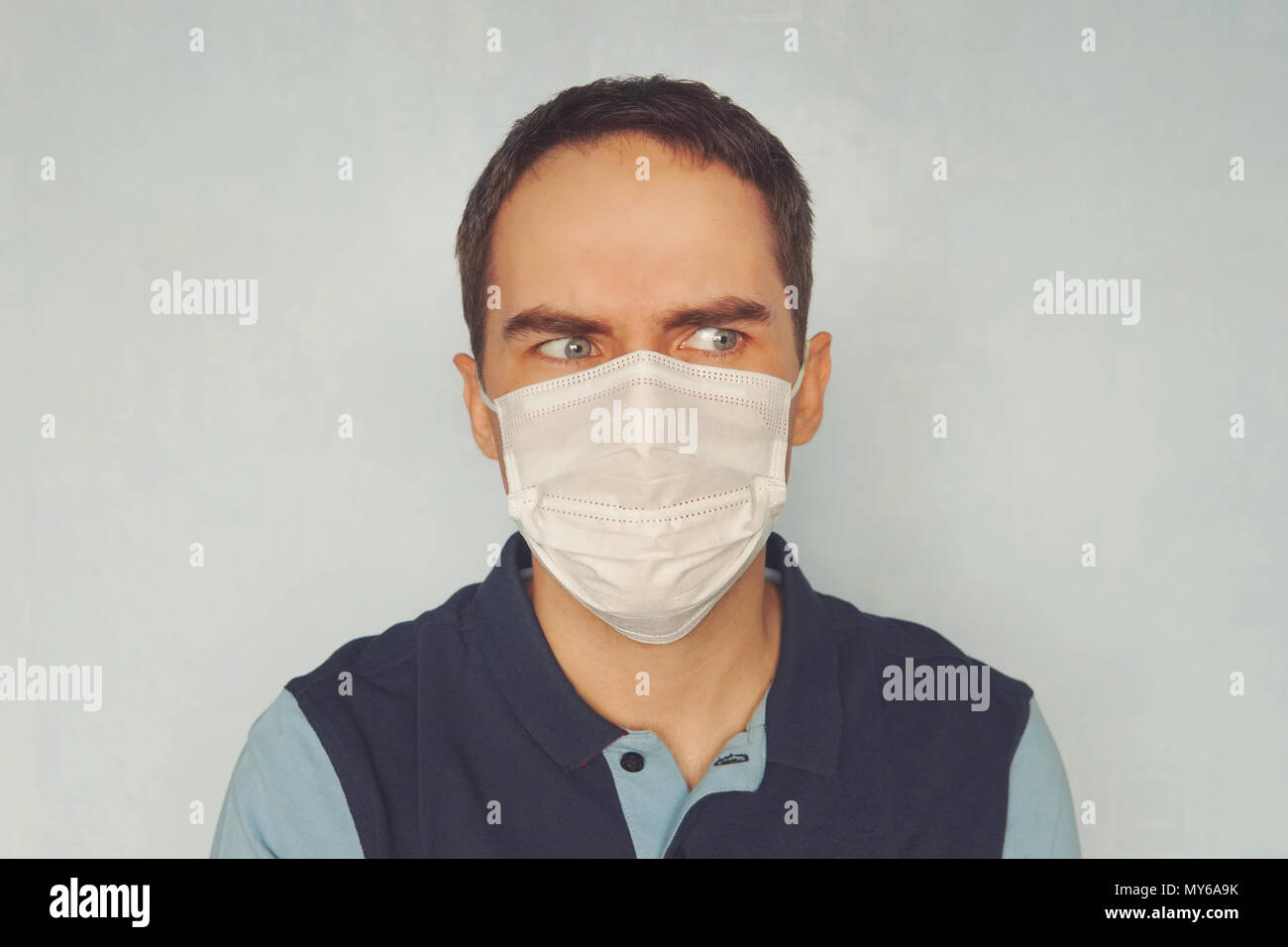 Dans l'homme masque médical fond bleu. quarantaine. Jeune beau gars dans un masque de médecin. Situation épidémiologique. Protection contre les microbes pathogènes Banque D'Images