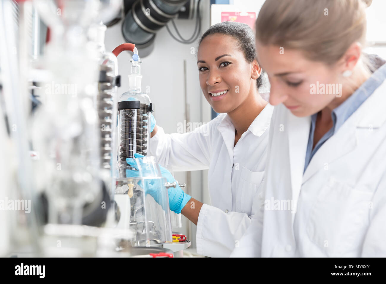 Groupe de scientifiques avec des gants et des blouses de laboratoire dans Banque D'Images