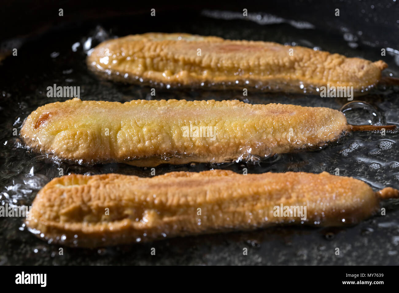 - Chiens de maïs dans la casserole de cuisson avec de l'huile de tournesol - vue rapprochée Banque D'Images